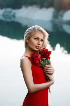 Pretty woman with a bouquet of peony. On the background of the sea.