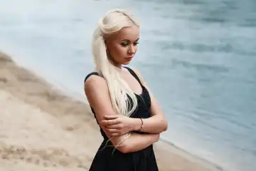 Pretty woman in black dress on the beach
