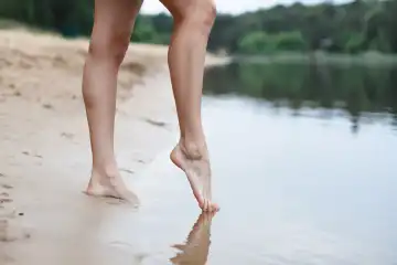Beautiful female legs go into the water