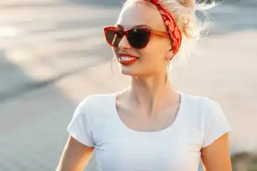 Beautiful hipster woman with red lips and sunglasses in the street.