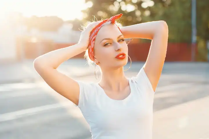 Schönes Mädchen im Retro-Stil mit roten Lippen und einer Bandage auf dem Kopf. Sonnenuntergang