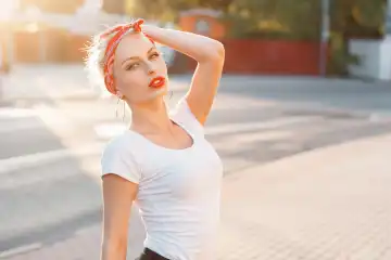 Beautiful girl in retro style with red lips and a bandage on head. sunset