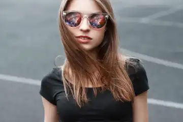 Beautiful girl in sunglasses. In the glasses reflection of space.