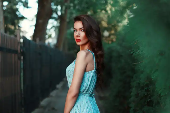 Porträt eines schönen Mädchens in einem blauen Kleid bei einem Spaziergang