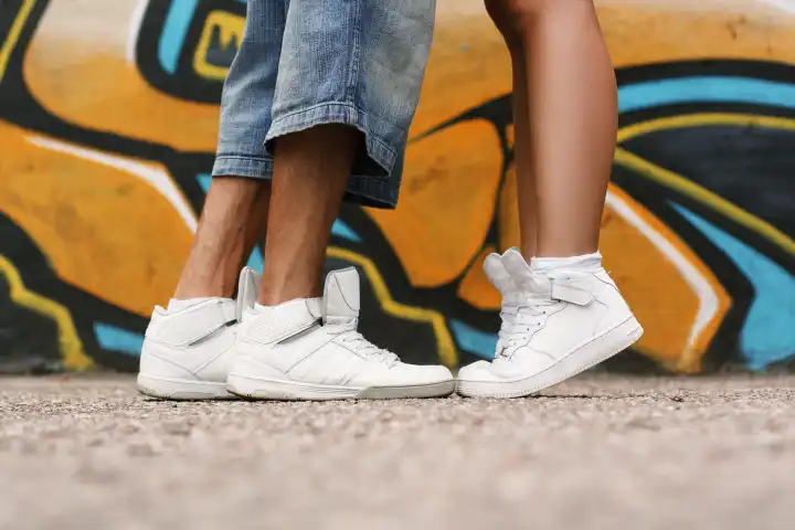 Verliebtes Paar. Schuhe in Großaufnahme. Weiße Schuhe auf dem Asphalt.