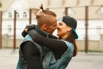 Young couple hugging and kissing at the stadium. Dancers in denim clothes.
