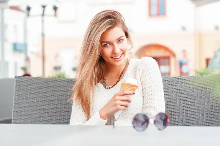 Porträt einer jungen, glücklichen Frau, die Eis isst, im Freien