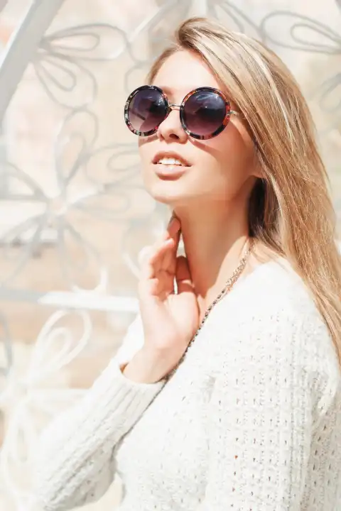 Beautiful young fashionable girl in round sunglasses