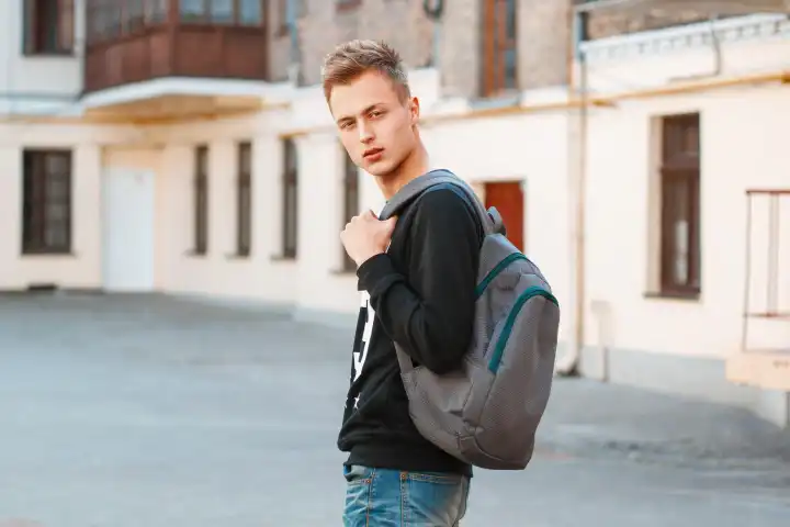 Young man with a backpack is traveling around the city.