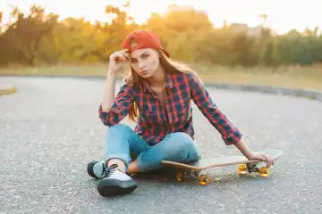 Teenager with skateboard portrait outdoors.