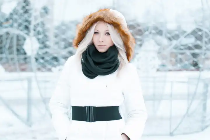 Schöne Frau in einer Winterjacke steht in der Stadt