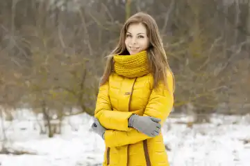 Pretty woman in a yellow knit scarf. Outdoor portrait in the park.