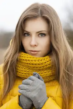 Pretty woman in a yellow knit scarf. ?ool weather.
