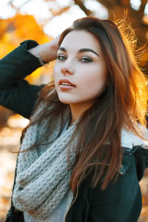 Porträt eines jungen schönen Mädchens in einem Strickpullover an einem sonnigen Herbsttag