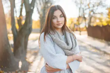 Pretty woman in knitted sweater on the background of autumn park