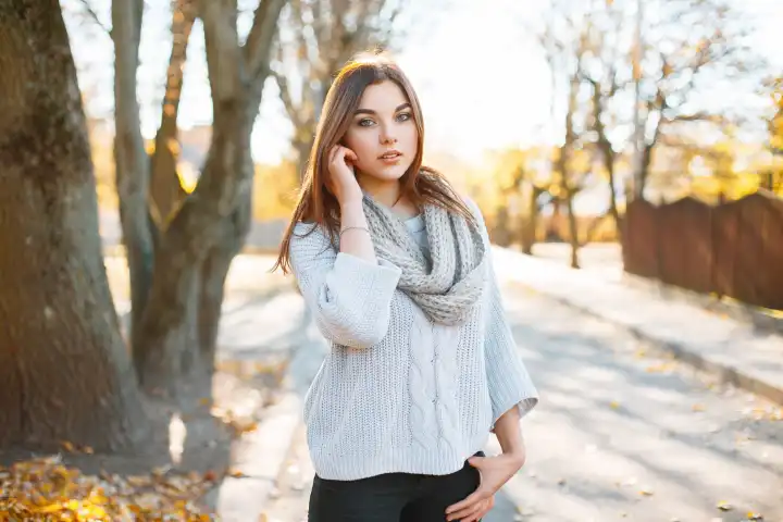 Beautiful young woman in vintage knitted sweater on the background of autumn park