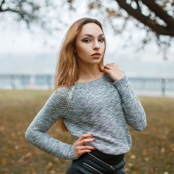 Pretty woman in a knitted sweater in a foggy autumn day