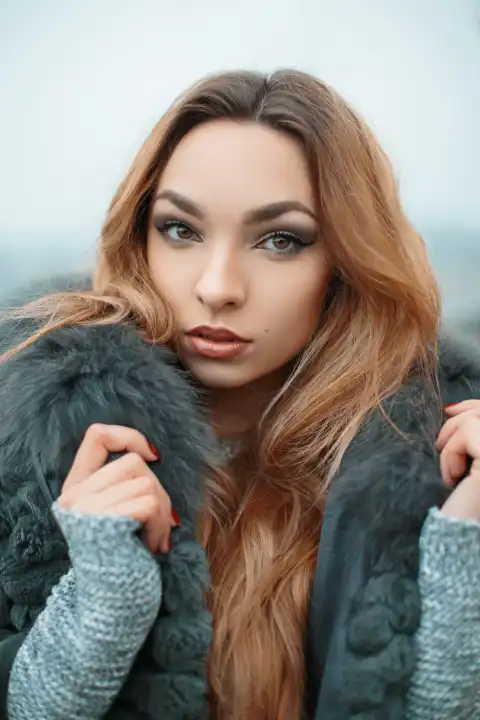 Close-up portrait of pretty fashionable girl in a jacket with fur