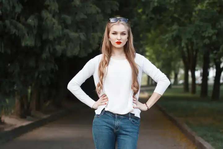 Beautiful portrait of a pretty woman with red lips in the park.