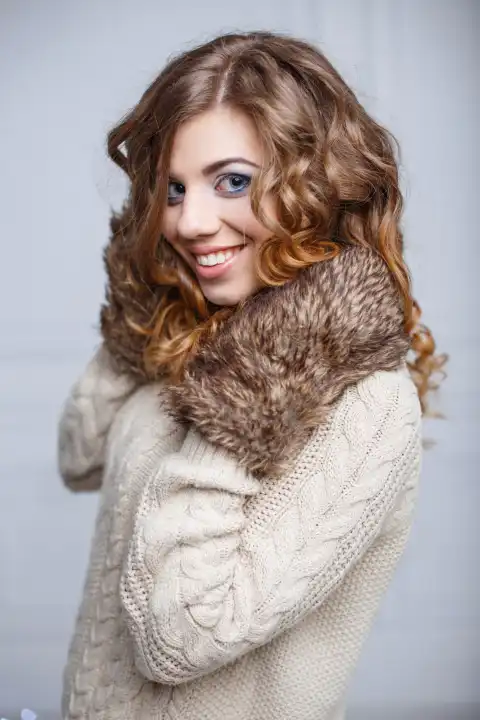 Schöne glückliche Frau mit einem charmanten Lächeln in winterlicher Kleidung.