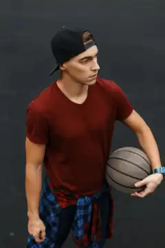 Hübscher Mann spielt Basketball, im Freien