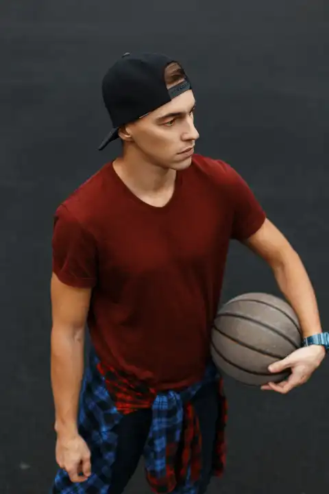 Handsome guy playing basketball, outdoors