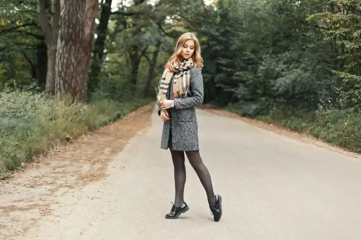 Schönes Mädchen im Herbst stilvolle Kleidung posiert im Park.