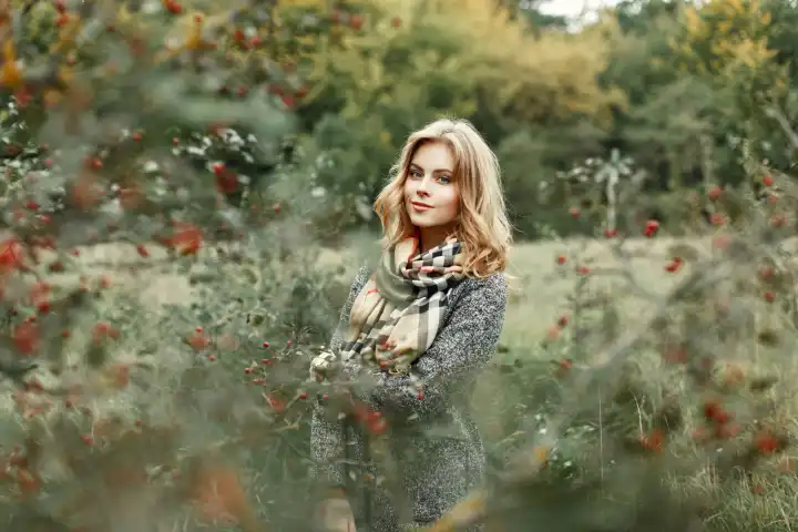 Schönes Mädchen in warmer Kleidung zu Fuß im Herbst Garten