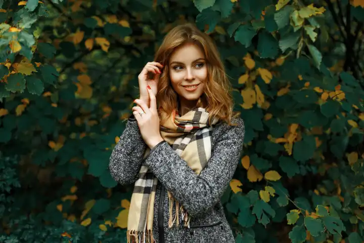 Schönes junges Mädchen auf dem Hintergrund von Herbstblättern.