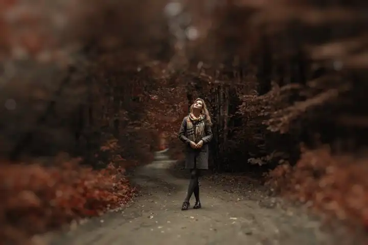 Junge Frau in Mantel und Schal spazieren in einem wunderschönen Park