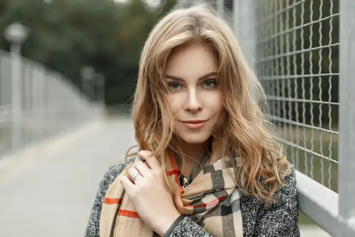 Porträt einer schönen jungen blonden Frau im Herbst Vintage-Schal in der Nähe von Metallgitter