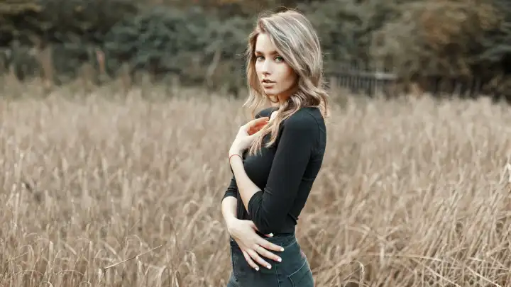 Sexy junge Frau im schwarzen Hemd in einem Maisfeld stehend