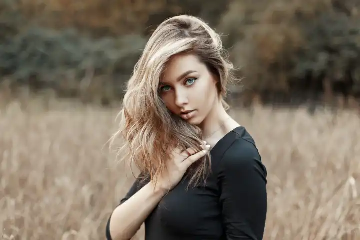 Schöne junge Frau im schwarzen Hemd auf dem Weizenfeld