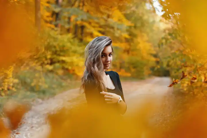 Schöne junge Frau in einem schwarzen Hemd im Park im Herbst Tag. Herbstlaub.