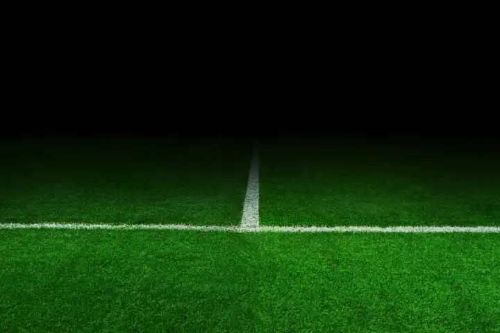 Fußballstadion bei Nacht. Fußball und grünes Feld in der Dunkelheit