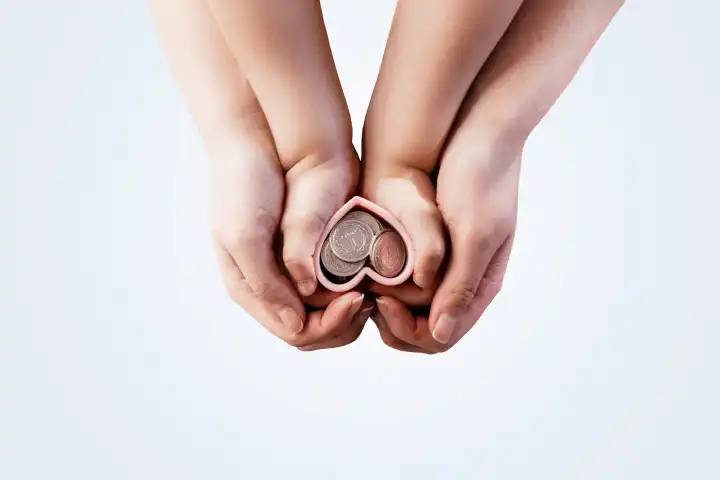 Financial Literacy Ausbildung von der Kindheit Konzept. Mutter mit einem Kind hält Hände Herzen mit polnischen Zloty-Münzen. Finanzielle Einsparungen und erfolgreiche Investitionen.