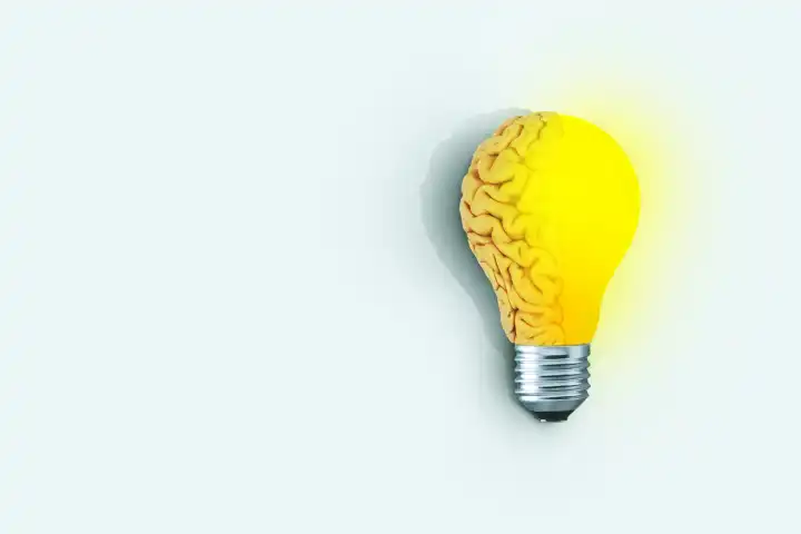 Kreative Gehirn Glühbirne leuchtet auf hellen blauen Hintergrund, Konzept. Anders denken, kreative Idee. Brainstorming. Kreatives Denken