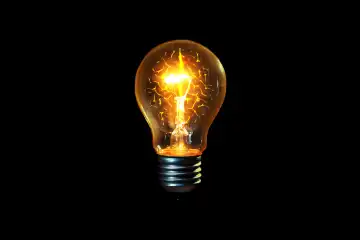 Creative light bulb glows with a brain on a black background, a creative idea. Thinking concept and brainstorm
