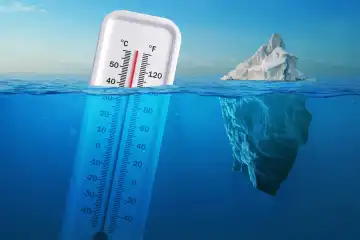 Iceberg in clear blue water and hidden danger under water. Global Warming Concept. Floating ice and a thermometer with a high temperature in ocean. Abnormal heat, concept. Warming, creative idea
