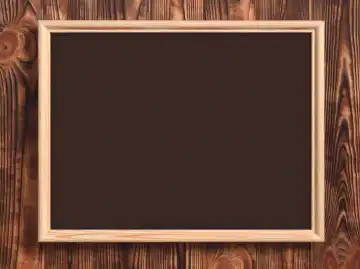 Wooden blank chalkboard with frame and brown background. Board for captions or school lessons.