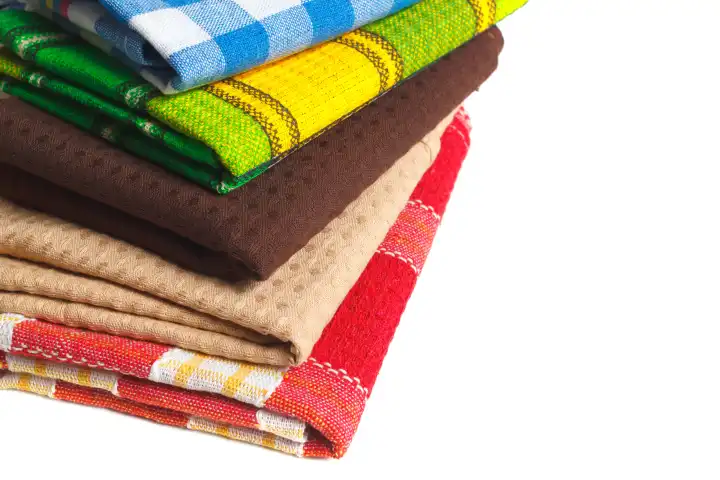 Der Stapel bunter Küchentücher. Textile Geschirrwischkleidung isoliert auf weiß mit Kopierbereich für Designelemente.