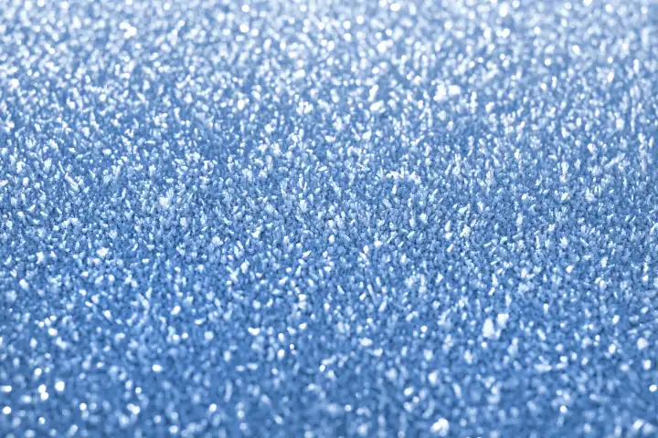 Eiskristalle auf der Oberfläche. Natürlicher Frostmakro-Hintergrund mit flachem DOF und Bokeh-Effekt.