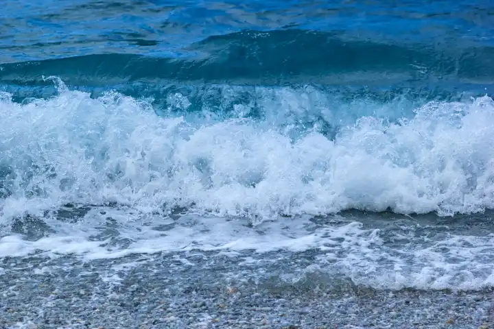 Meerwasser spritzt mit Schaum. Welle auf Sand des Strandes vom blauen Meer.