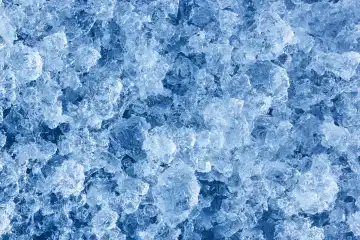Die natürlichen gehackten Eiskristalle. Glänzendes gefrorenes abstraktes Muster für Hintergrund oder Hintergrund. Blick von oben.