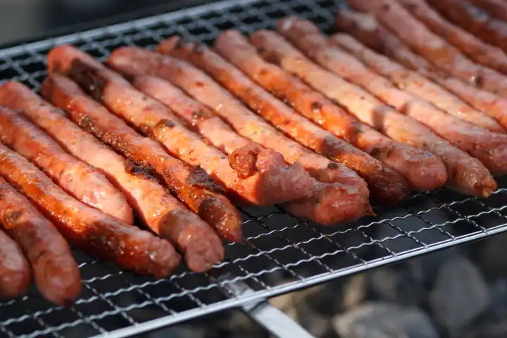 The pork meat sausages smoked on grill outdoors. Closeup view.