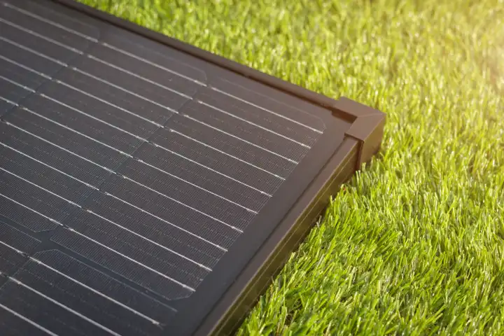 Elektrisches Solarmodul auf grünem Gras. Die moderne Technologie der sauberen und erneuerbaren Energieerzeugung.