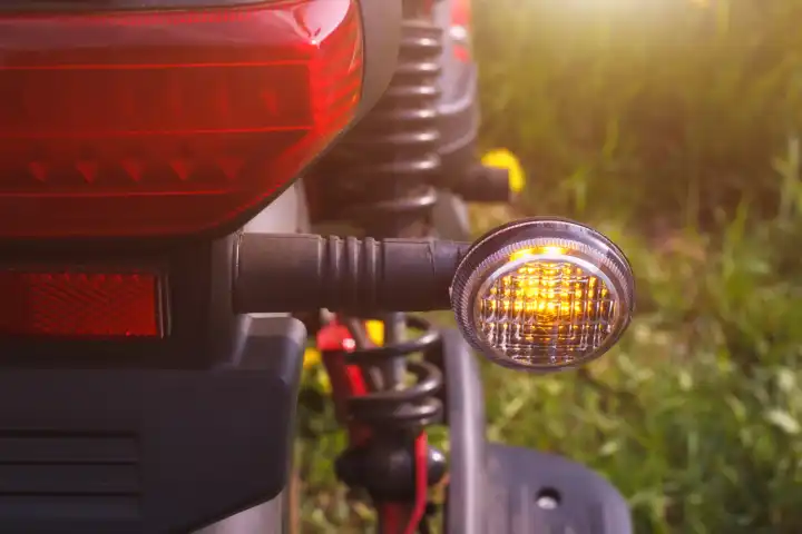 Das rechte Blinklicht eines am Straßenrand geparkten Rollers oder Fahrrads. Die Nahaufnahme der Richtung Sicherheitssignal mit im Freien Sommer Umwelt.