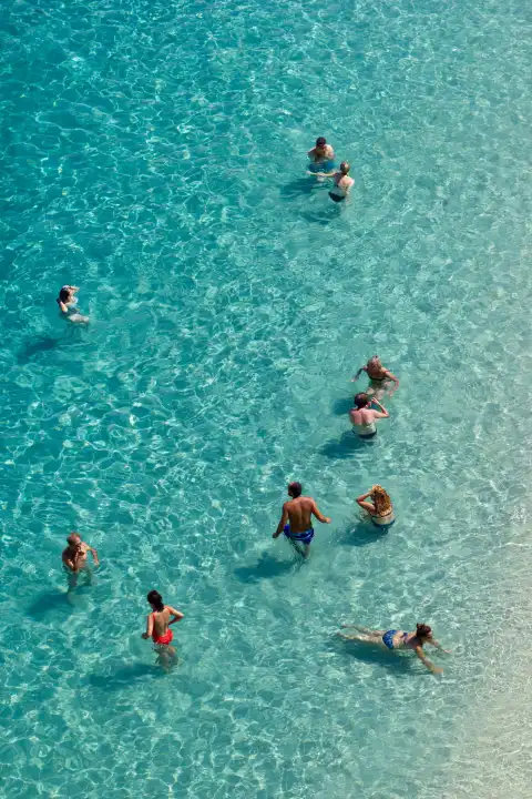 Gruppe von Menschen schwimmen im sauberen blauen Wasser des Tyrrhenischen Meeres. Luftaufnahme am Strand in Süditalien.