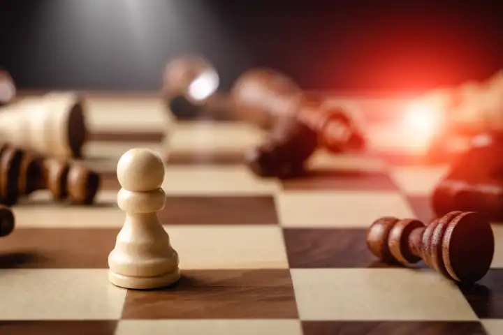 Schachfigur Konzept für Selbstvertrauen, Sieg und Stärke, kleine Figur geht als Gewinner und Sieger aus dem Kampf