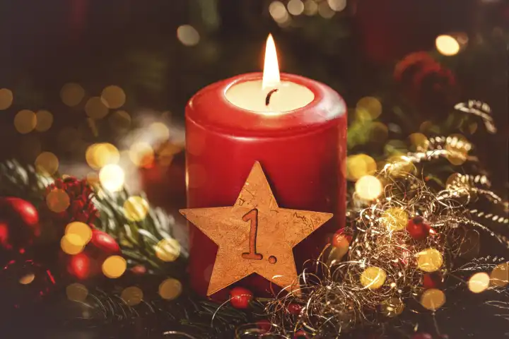 Symbolbild Erster Advent Sonntag, rote brennende Kerze mit einem goldenen Stern auf einem Adventskranz. 1 Advents Gruß FOTOMONTAGE